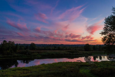 Scenic view of agricultural landscape against sky during sunset