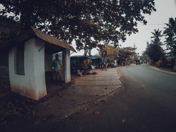 Street amidst buildings and trees against sky