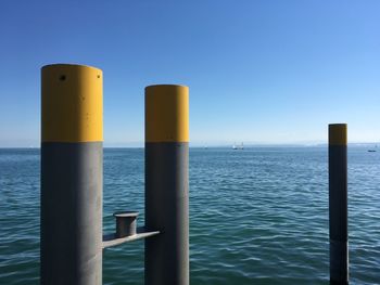 Metallic pole at lake constance against clear blue sky