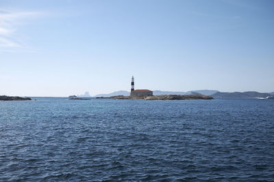 Scenic view of sea by building against clear sky
