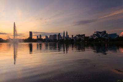 Reflection of buildings in river during sunset