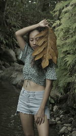 Midsection of woman standing against plants