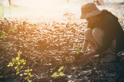 Side view of woman sitting on field