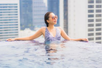 Young woman sitting on swimming pool