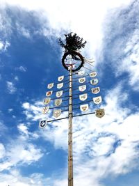 Low angle view of weather vane against blue sky