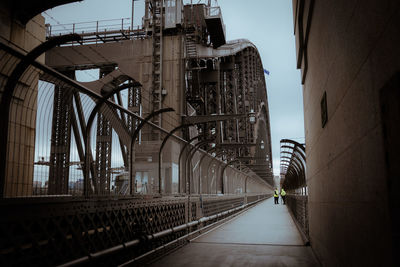 Bridge amidst buildings in city against sky