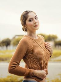 Portrait of beautiful woman standing against clear sky