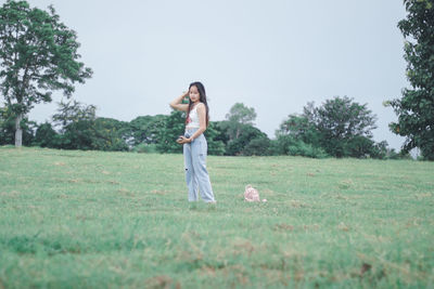 Woman standing on field against sky