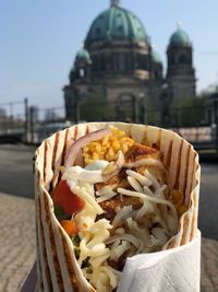 Close-up of food in city against sky