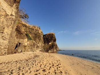 Scenic view of beach against clear blue sky