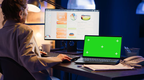 Midsection of woman using laptop at office