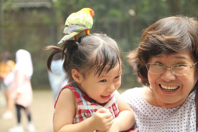 Close-up of smiling grandmother with granddaughter at park