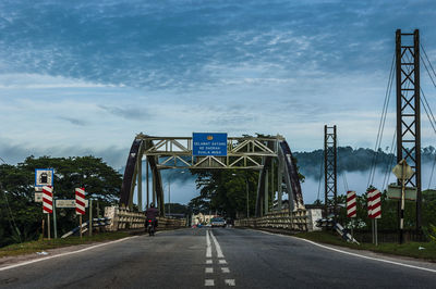 Vehicles on bridge against sky