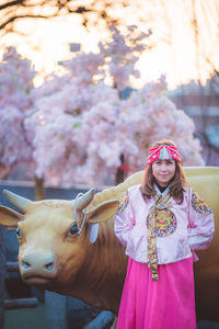 Portrait of woman with pink standing outdoors