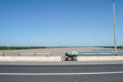 Bicycles on road against clear blue sky