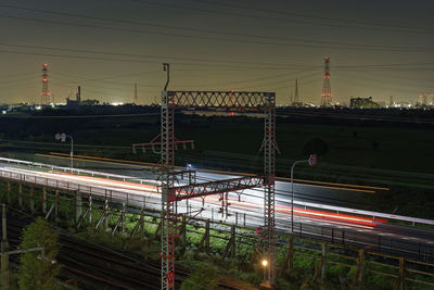 Light trails on railroad tracks against sky at night