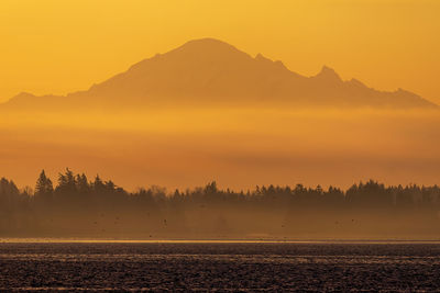 Scenic view of silhouette mountains against sky during sunset