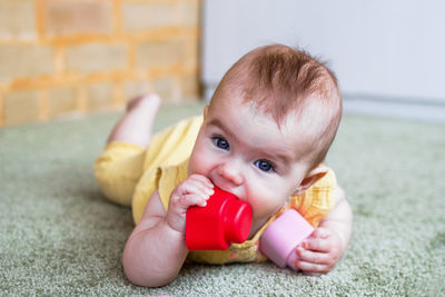 Little caucasian girl playing with soft plastic constructor at home.