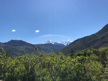 Scenic view of mountains against blue sky