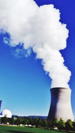 Smoke emitting from chimney against blue sky