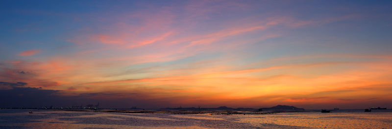 Scenic view of sea against dramatic sky during sunset