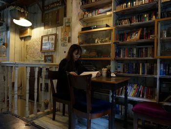 Young woman sitting on table at home