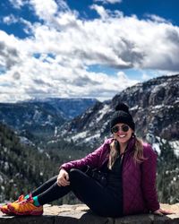 Portrait of young woman sitting on mountain