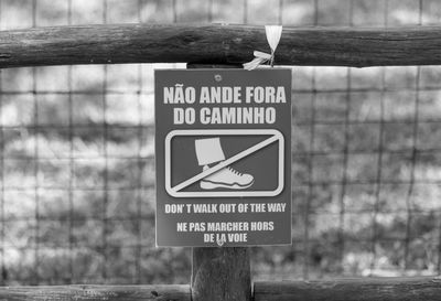 Close-up of warning sign on fence