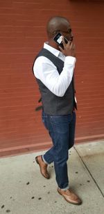 Full length of man photographing against wall