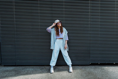 Fashionable funky caucasian girl dancer in sportswear is performing outdoor street dancing motion .