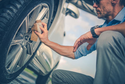 Midsection of man repairing car