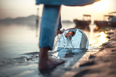 Close-up of man by sea against sky