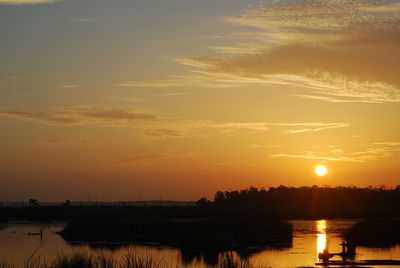 Scenic view of lake against romantic sky at sunset