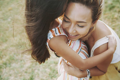 Smiling mature woman embracing daughter