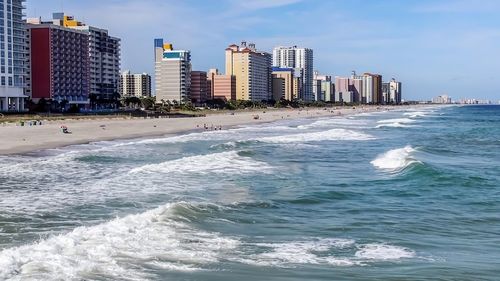 Scenic view of sea and buildings against sky
