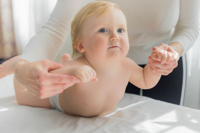 Mom does hand exercises to the baby. close-up.