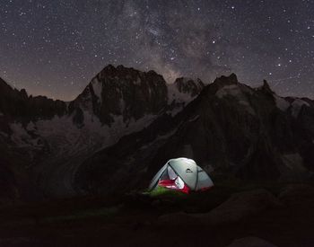 Scenic view of snowcapped mountains against sky at night