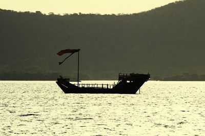 Boats in sea at sunset