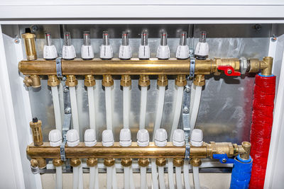 New manifold of underfloor heating system, plastic pipes and valves visible, serving nine circuits.