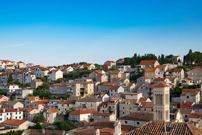 Aerial view of townscape against clear blue sky