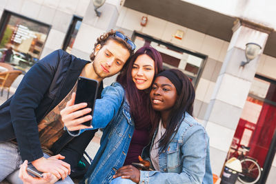 Portrait of smiling young woman using mobile phone