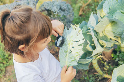 Girl looking at leaf through magnifying glass