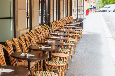 Empty chairs and tables in cafe outdoors