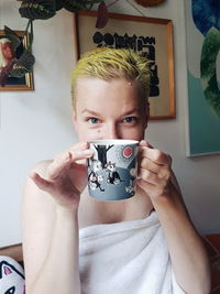 Portrait of boy drinking mannequin at home