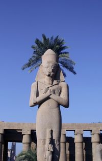 Low angle view of statue against clear blue sky