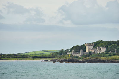 Scenic view of sea and houses against sky