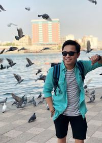 Smiling man looking away while standing on promenade