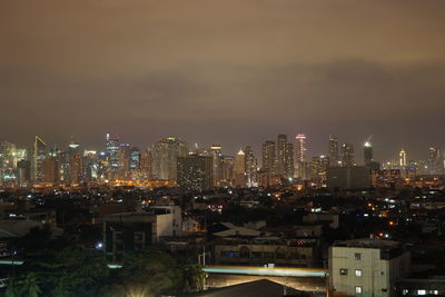 Illuminated cityscape against sky at night