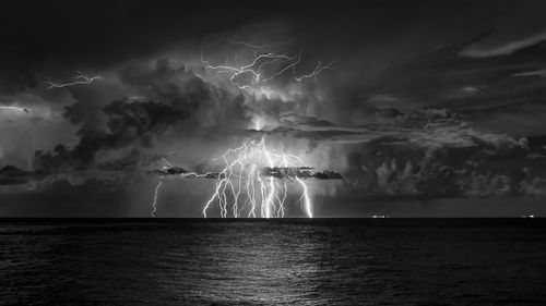 Lightning over sea against sky at night