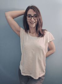 Portrait of smiling young woman standing against white background